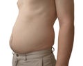 Young man shows fat belly on white background