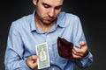 A young man shows that he has in the wallet a one dollar