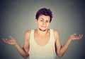 Young man shrugging shoulders who cares so what I don't know gesture Royalty Free Stock Photo