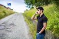 Young man on side of a road, calling and waiting Royalty Free Stock Photo