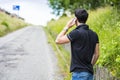 Young man on side of a road, calling and waiting Royalty Free Stock Photo