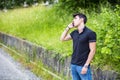 Young man on side of a road, calling and waiting Royalty Free Stock Photo