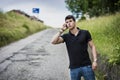 Young man on side of a road, calling and waiting for taxi Royalty Free Stock Photo