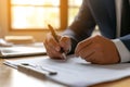 Young man signing an official document, male hand holding pen putting signature at paper contract agreement. Business, lawyer, Royalty Free Stock Photo