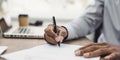 Young man signing an oficial document, male hand holding pen putting signature at paper contract agreement Royalty Free Stock Photo