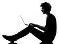 Young man silhouette sitting computing laptop Royalty Free Stock Photo