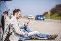 Young man with a silver car that broke down on the road Royalty Free Stock Photo