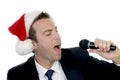 Young man singing into microphone with santa cap Royalty Free Stock Photo