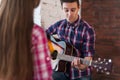 Young man singing playing guitar for his girlfriend Royalty Free Stock Photo