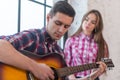 Young man singing playing guitar for his girlfriend Royalty Free Stock Photo