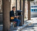 A young man sings and plays a Georgian string instrument on the street in the old part of Tbilisi city in Georgia