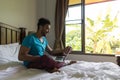 Young Man Sit On Bed, Happy Smile Hispanic Guy Bedroom Using Laptop Computer Royalty Free Stock Photo