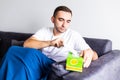 Young man sit on couch feel unwell blowing running nose with napkin at home. Sick male at home have health problems, get flu or Royalty Free Stock Photo