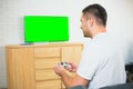 Young man sit in room during quarantine. Guy playing games alone using joystick or gamepad. Green screen on tv. Gaming Royalty Free Stock Photo