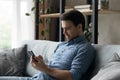 Young man sit on sofa with smart phone