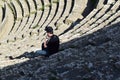 A young man sitting on roman theatre stairs in Djemila city, Setif, Algeria on April 15, 2016 Royalty Free Stock Photo