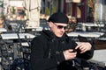 Young man sits alone on chair of an outside cafe terrace on. Royalty Free Stock Photo