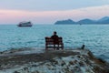 Young man sits lonely at the seaside at dusk. Dream. Royalty Free Stock Photo