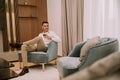 Young man sits in a luxury apartment, drinking red wine and and relaxing Royalty Free Stock Photo