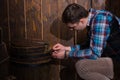 Young man sits near a barrel and trying to solve a conundrum to Royalty Free Stock Photo