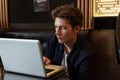 Young man sits at a table in front of a laptop Royalty Free Stock Photo