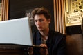 Young man sits at a table in front of a laptop Royalty Free Stock Photo