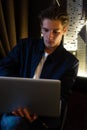 Young man sits at a table in front of a laptop Royalty Free Stock Photo