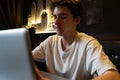 Young man sits at a table in front of a laptop. Royalty Free Stock Photo