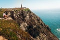 Young man sitting alone and looking at atlantic ocean on Cabo Da Roca rocks, Portugal