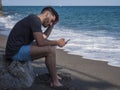 Young man sitting on a beach alone and lonely Royalty Free Stock Photo