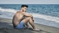 Young man sitting on a beach alone and lonely Royalty Free Stock Photo