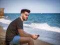 Young man sitting on a beach alone and lonely Royalty Free Stock Photo