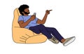 Young man sitting in bean bag chair with phone.