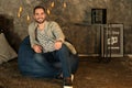 Young man sitting on beanbag chair at home Royalty Free Stock Photo