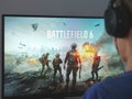A young man sitting behind a computer with the Battlefield 6 game loading screen on it Royalty Free Stock Photo