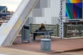 A young man sitting on a bench on the John Seigenthaler Pedestrian Bridge in Nashville