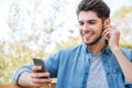 Young man sitting on the bench in park with phone Royalty Free Stock Photo