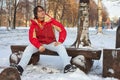 Young man sitting on bench in winter park Royalty Free Stock Photo