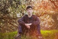 Young man sitting by blooming tree Royalty Free Stock Photo