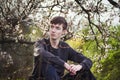 Young man sitting by blooming tree Royalty Free Stock Photo