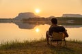A young man sitting on a chair at mountain lake with relaxing mood, lonely man, Asian man travel alone Royalty Free Stock Photo
