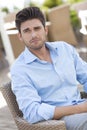 Young man sitting on chair at outdoors cafe Royalty Free Stock Photo