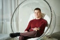 Young man is sitting in a chair smiling at camera