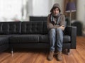 Young man sitting on couch is feeling cold at home. Royalty Free Stock Photo