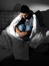 Young man sitting on couch at home suffering depression and crisis Royalty Free Stock Photo