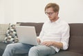 Young man sitting on couch with laptop Royalty Free Stock Photo