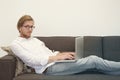 Young man sitting on couch with laptop Royalty Free Stock Photo