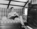 Young man sitting on a couch and playing a guitar Royalty Free Stock Photo