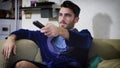 Young man sitting on couch watching television