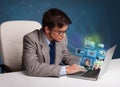 Young man sitting at desk and watching his photo gallery on laptop Royalty Free Stock Photo